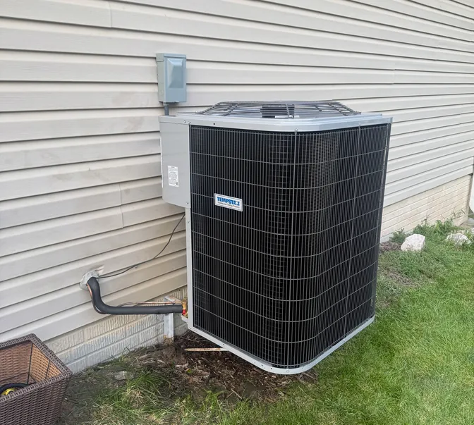 New Tempstar air conditioner installed on a pad next to a home by BreezeTech Heating and Cooling