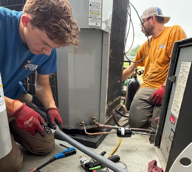 BreezeTech Heating and Cooling technicians brazing a line set at a new condensing unit