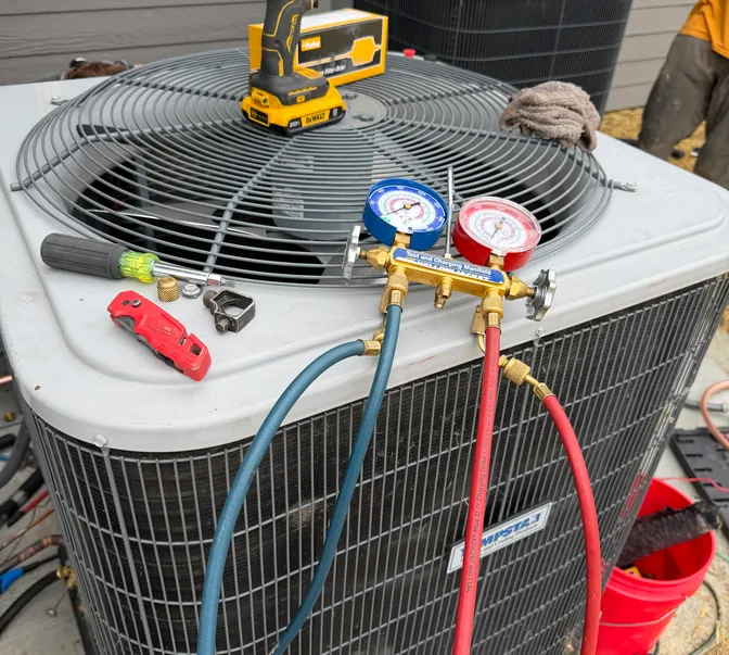 Manifold gauges and tools on a new condenser during a BreezeTech Heating and Cooling install