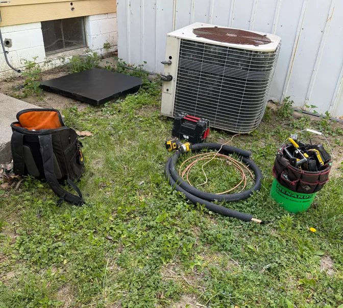 BreezeTech Heating and Cooling tools staged in the yard before an air conditioner replacement