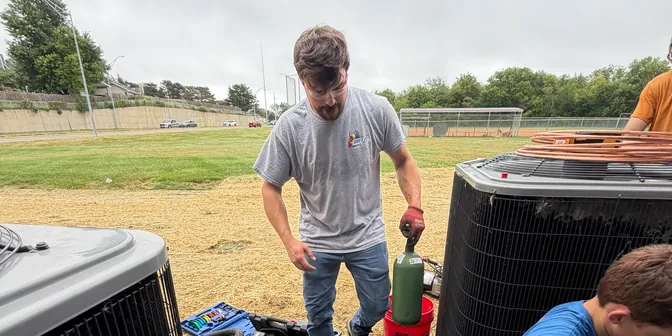 BreezeTech Heating and Cooling crew installing multiple air conditioning condensers