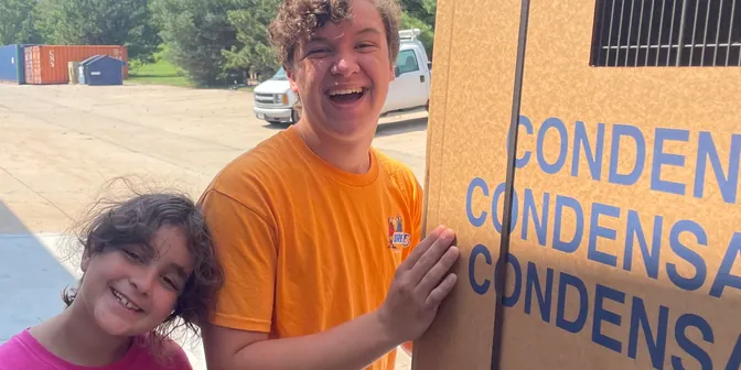 BreezeTech Heating and Cooling kids next to a new Tempstar condenser box, a truly family-run business