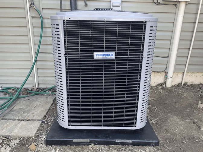 A Tempstar air conditioner condenser beside a home