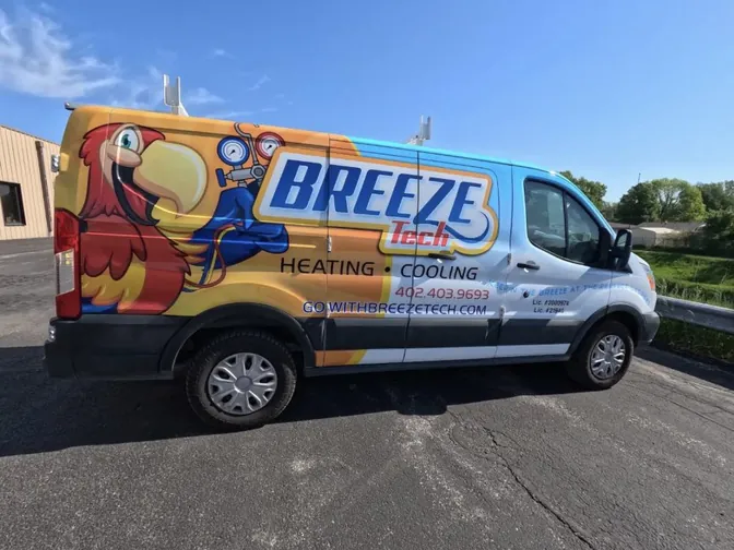 A BreezeTech service van with its parrot wrap parked on a sunny street