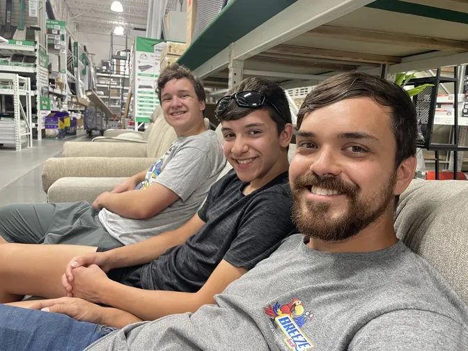 Silas, Theo, and Micah relaxing on display furniture at Menards