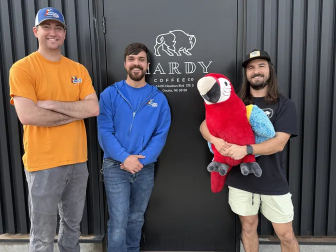 The BreezeTech crew with Max the Macaw outside Hardy Coffee Co. in Omaha