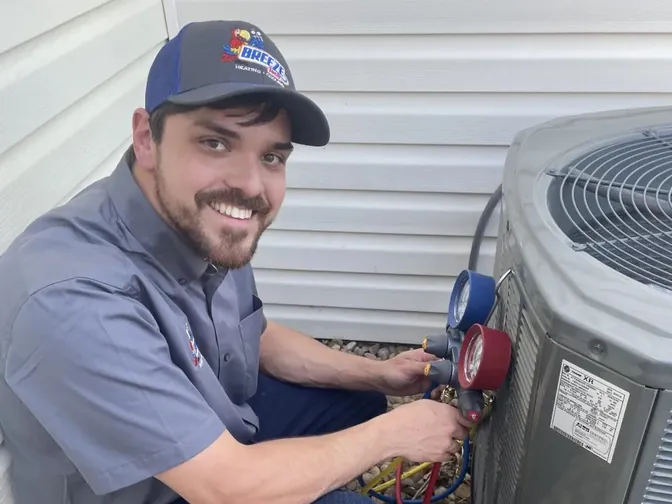A BreezeTech technician servicing an outdoor AC unit