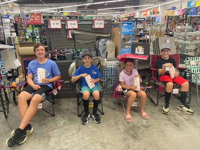 Four kids with popcorn in display lawn chairs at ACE Hardware