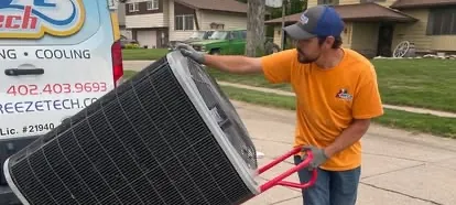 BreezeTech Heating and Cooling technician wheeling a new air conditioner condenser on a hand truck beside the company van