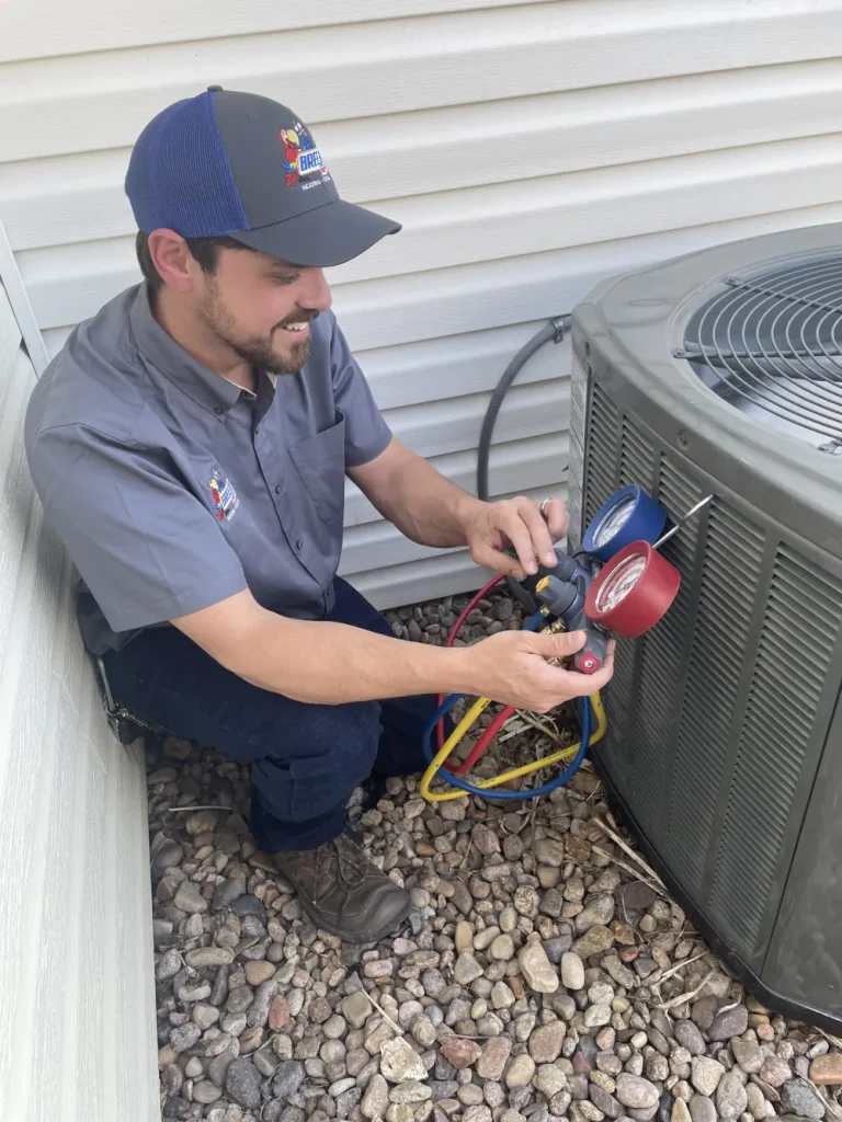 BreezeTech Heating And Cooling technician installing a new AC unit.