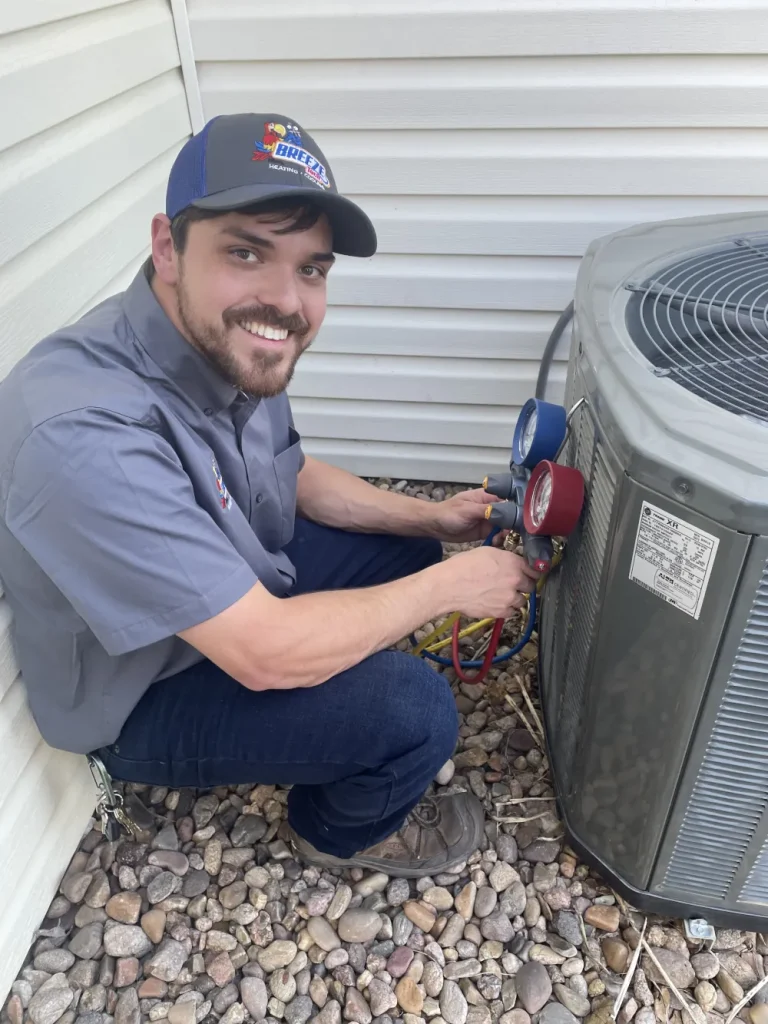 BreezeTech Heating & Cooling technician fixing an AC Unit.