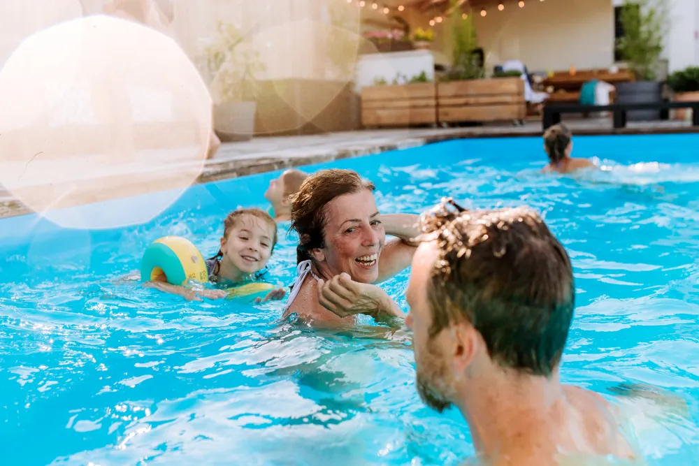 A couple with a child swimming in a pool.