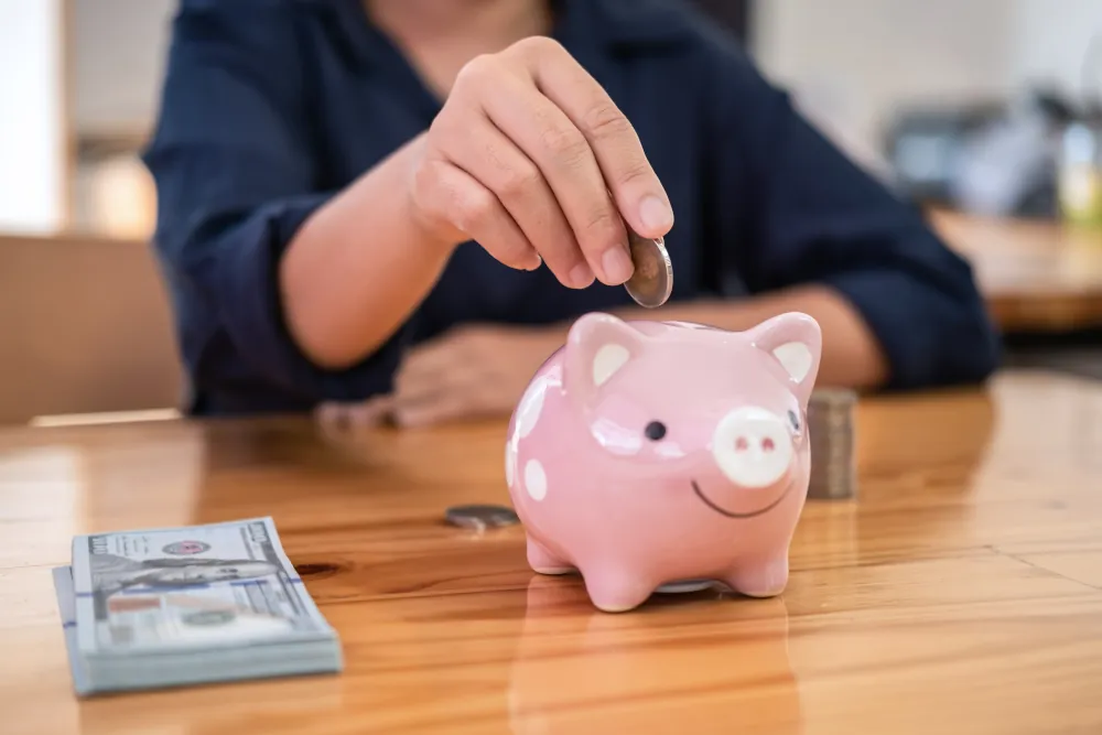 Woman putting hvac savings into piggy bank